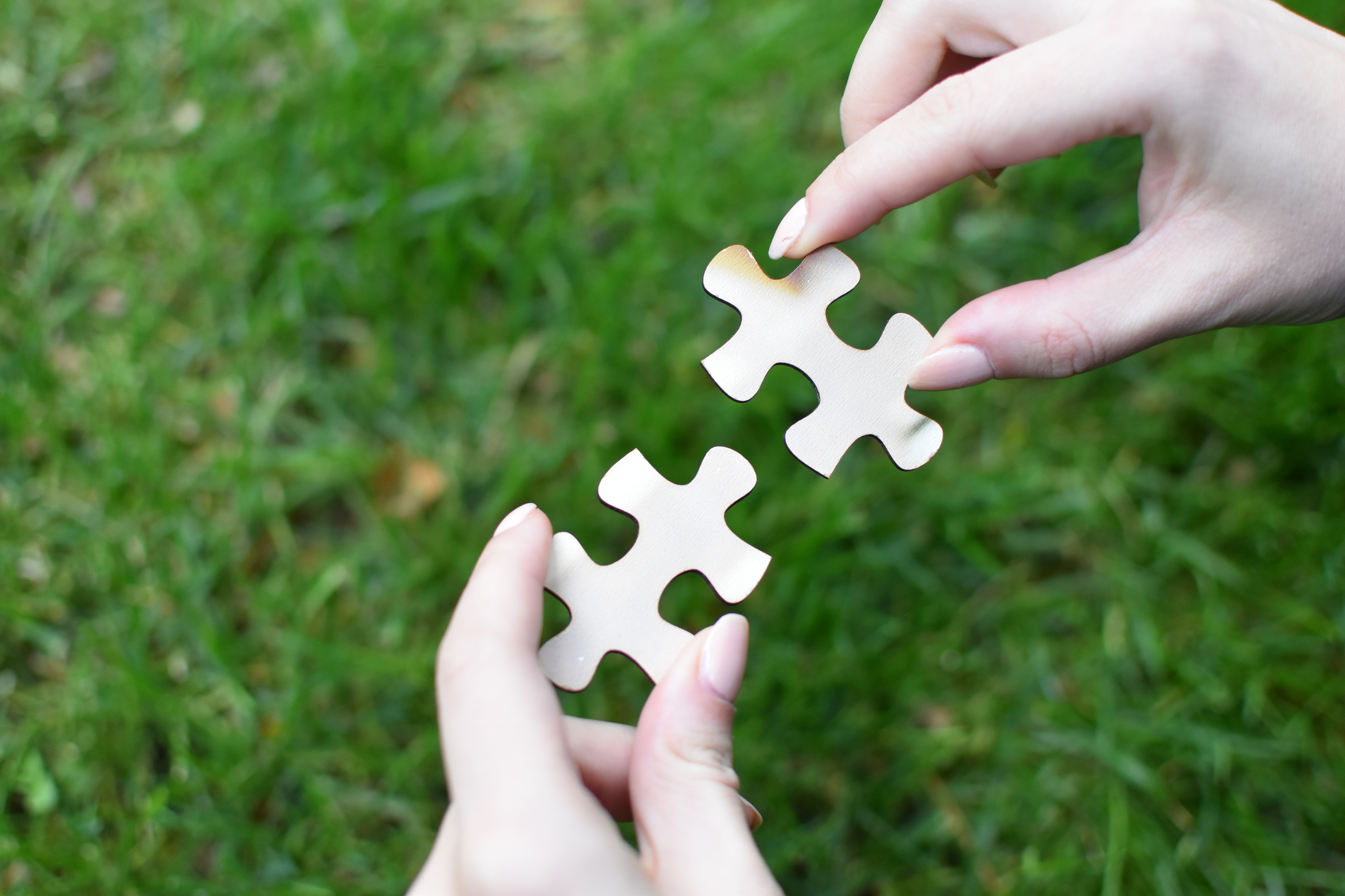 Two hands hold jigsaw pieces ready to be connected